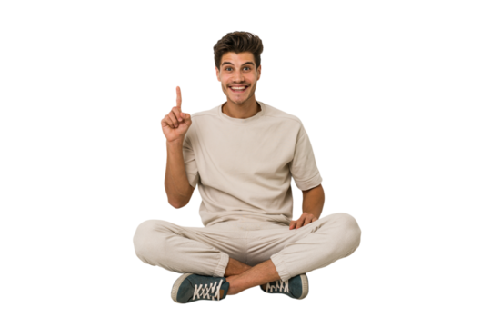 Young caucasian man sitting on the floor isolated on white background showing number one with finger.