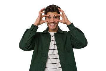 Young handsome caucasian man isolated on white background keeping eyes opened to find a success opportunity.