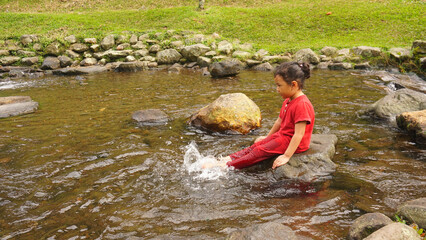 A daughter playing in a river with red clothes