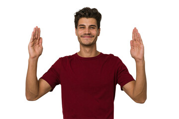Naklejka premium Young handsome caucasian man isolated on white background holding something little with forefingers, smiling and confident.