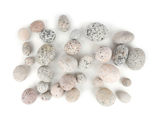 Sea washed oval pebbles isolated on white background. Arrangement of smooth round stones.