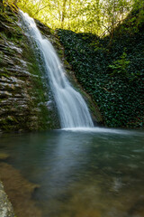 Fototapeta premium A waterfall is flowing into a pool of water