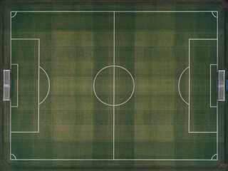 Aerial view of a soccer field, featuring bright green grass and white markings for play.