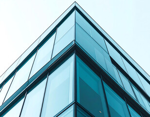 Obraz premium Modern glass building showcasing sleek lines and reflective surfaces, captured from a low angle against a clear sky