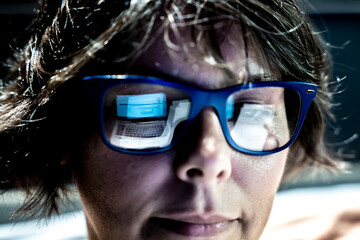 Beautiful Business Woman Face with Eyeglasses Reflection When She is Working on Her Laptop in Switzerland.