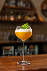 Orange Colour Cocktail in a Fancy Stem Glass on a Bar Counter