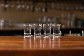 Vodka Shots Lined up in a Wooden Bar Counter