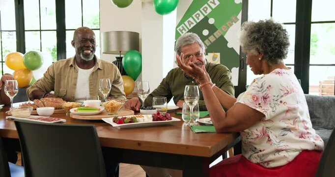 Group of happy senior multiracial, white and black male and female friends talking at retirement par