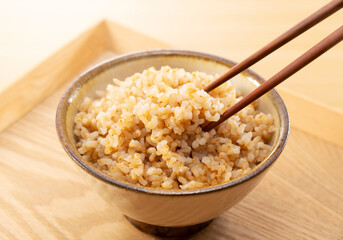 Freshly Cooked Brown Rice on a Table, Lifted with Chopsticks