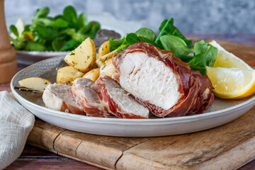 Prosciutto wrapped chicken with herby potatoes and green lettuce