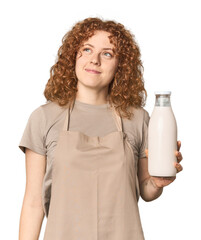 Young Caucasian redhead woman with milk dreaming of achieving goals and purposes