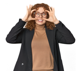 Young Caucasian redhead in business attire keeping eyes opened to find a success opportunity.