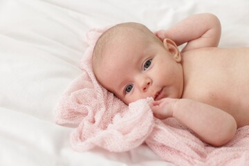 Cute little baby lying on bed at home