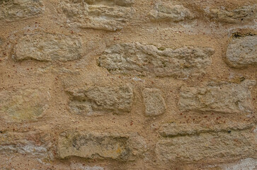 Stone wall features varied textures and earthy tones ideal for architectural backgrounds. High quality photo
