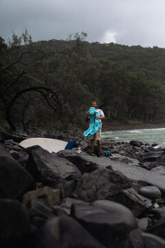 Man takes off wetsuit after surfing