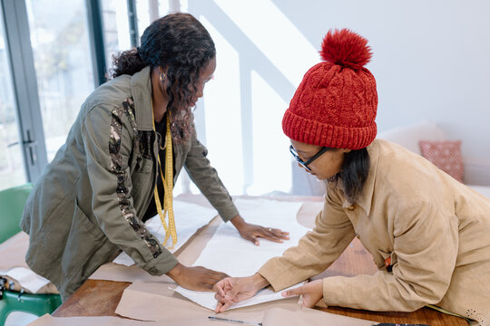 Two women cutting a pattern to sew