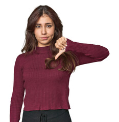 Middle Eastern woman in studio showing thumb down, disappointment concept.