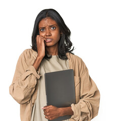 Young Indian woman studying with laptop biting fingernails, nervous and very anxious.