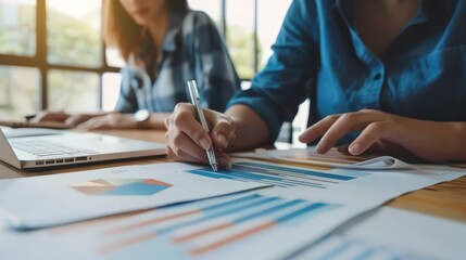 A close-up of an Asian consultant reviewing data reports with a team.