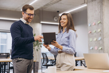 Obraz premium Business colleagues using tablet and working together in modern office