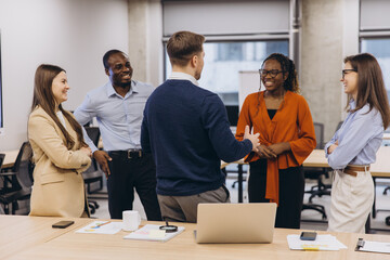Diverse professionals brainstorming, sharing insights, working together in contemporary workspace, showcasing collaborative corporate culture
