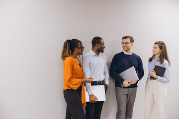 Diverse business team networking, sharing ideas on mobile devices during collaborative office meeting break
