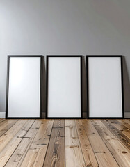 Three empty picture frames stand against a minimalist wall, showcasing a clean aesthetic with wooden flooring