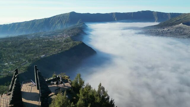 Aerial view of Bromo plateau covered with morning fog. Sunrise at Mentigen Hill.