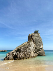 Naklejka premium Coastal Rock Formation in Turquoise Sea on Sunny Beach