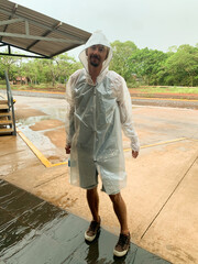 Man in Transparent Rain Poncho Standing in Wet Outdoor Area