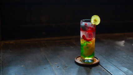 Refreshing iced nutmeg juice or pala juice with colorful jelly and syrup in highball glass, on wood surface, with shallow depth of field