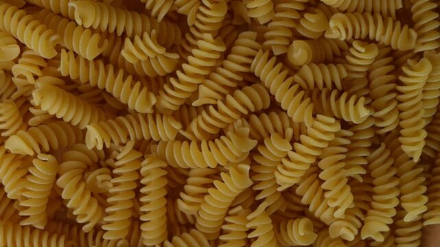 Raw Fusilli Spiral spaghetti pasta pattern background.
