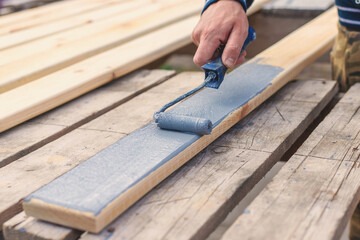 A man paints a board with paint. Selective focus.