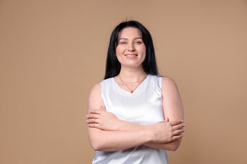 Obraz premium Portrait of smiling plus size model on beige background. Overweight