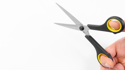 Close-up of a hand holding scissors ready for cutting tasks in a bright workspace environment