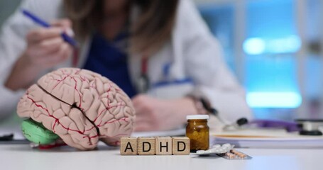 Female doctor writes prescription for ADHD treatment with brain model pills and stethoscope on desk. Neurological aspects and medication options