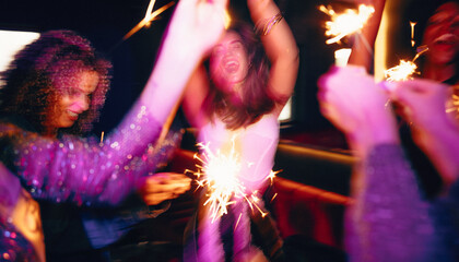 Group celebrating together with sparklers in a vibrant party atmosphere