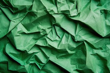 Obraz premium Close-up of crumpled, vibrant green paper. Textured surface with deep folds and creases