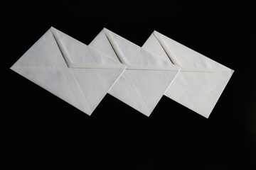 An image of a set of paper envelopes on a black background creates a sense of order, rigor, and...