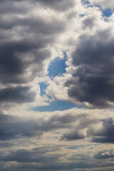 A glimpse of blue sky in a wall of gray clouds, gray clouds, background, change in weather.