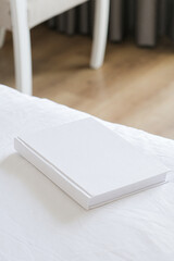 White book mockup on white bed