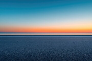 Serene sunset over calm ocean, asphalt foreground