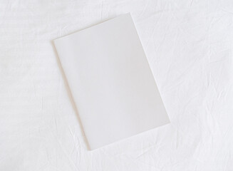 White magazine mockup on white bed