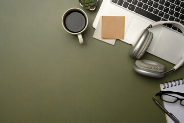 Fototapeta na wymiar Flat lay of stylish desktop with laptop, coffee cup, headphones, and planner on green desk