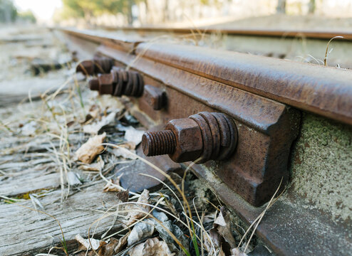 Old railroad ties and rusty nuts and rails of a narrow-gauge railway