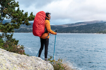 Latina hiker smiling while overlooking landscape from mountain ridge