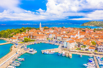 A charming aerial view of Izola, Slovenia, a picturesque coastal town on the Adriatic Sea, featuring a historic old town, marina, and a scenic shoreline full of Mediterranean character