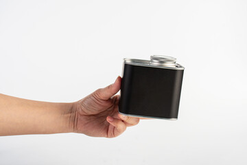Black can for packaging in hand on white background.