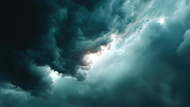 Dramatic storm cloudscape reveals a break in the dark sky with sunlight filtering through