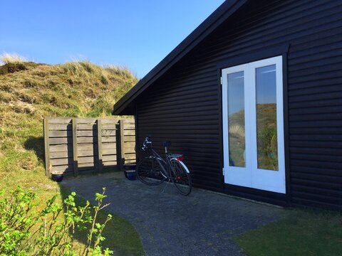 Bicycle parked outside a traditional timber summerhouse on a sunny summer day, Fanoe, Jutland, Denmark